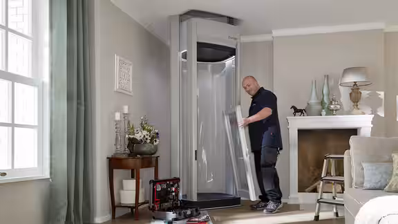 Ein LIFTON Mitarbeiter montiert den Homelift in der Ecke eines Wohnzimmers