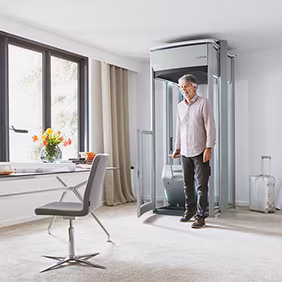 Mann mit schwerem Koffer verlässt den LIFTON Homelift