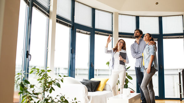 Lifteinbau Lifton Expertin zeigt Pärchen mögliche Platzierung des Homelifts im Wohnzimmer